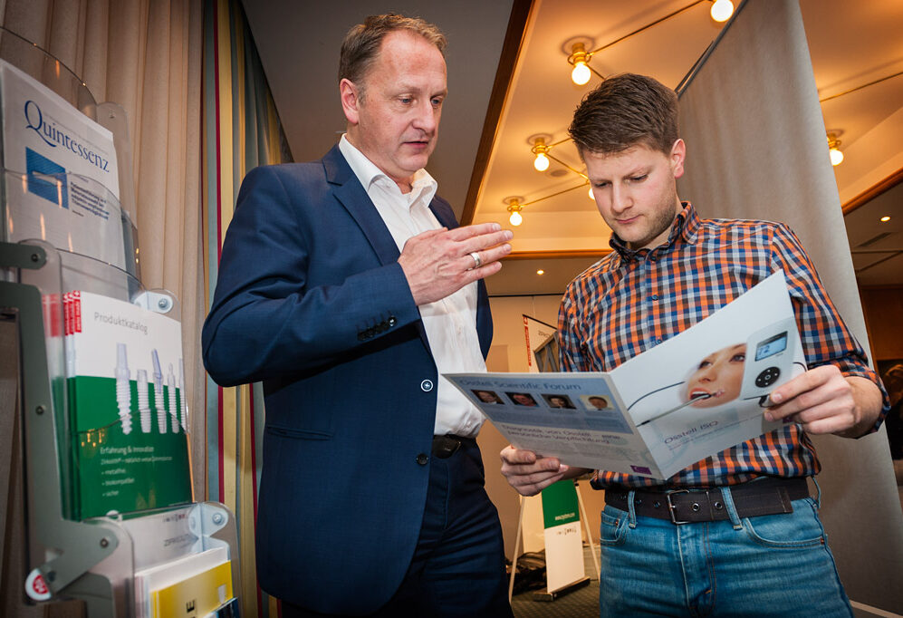 Vertreter zeigt Prospekt - Fortbildung Zirkon Implantate