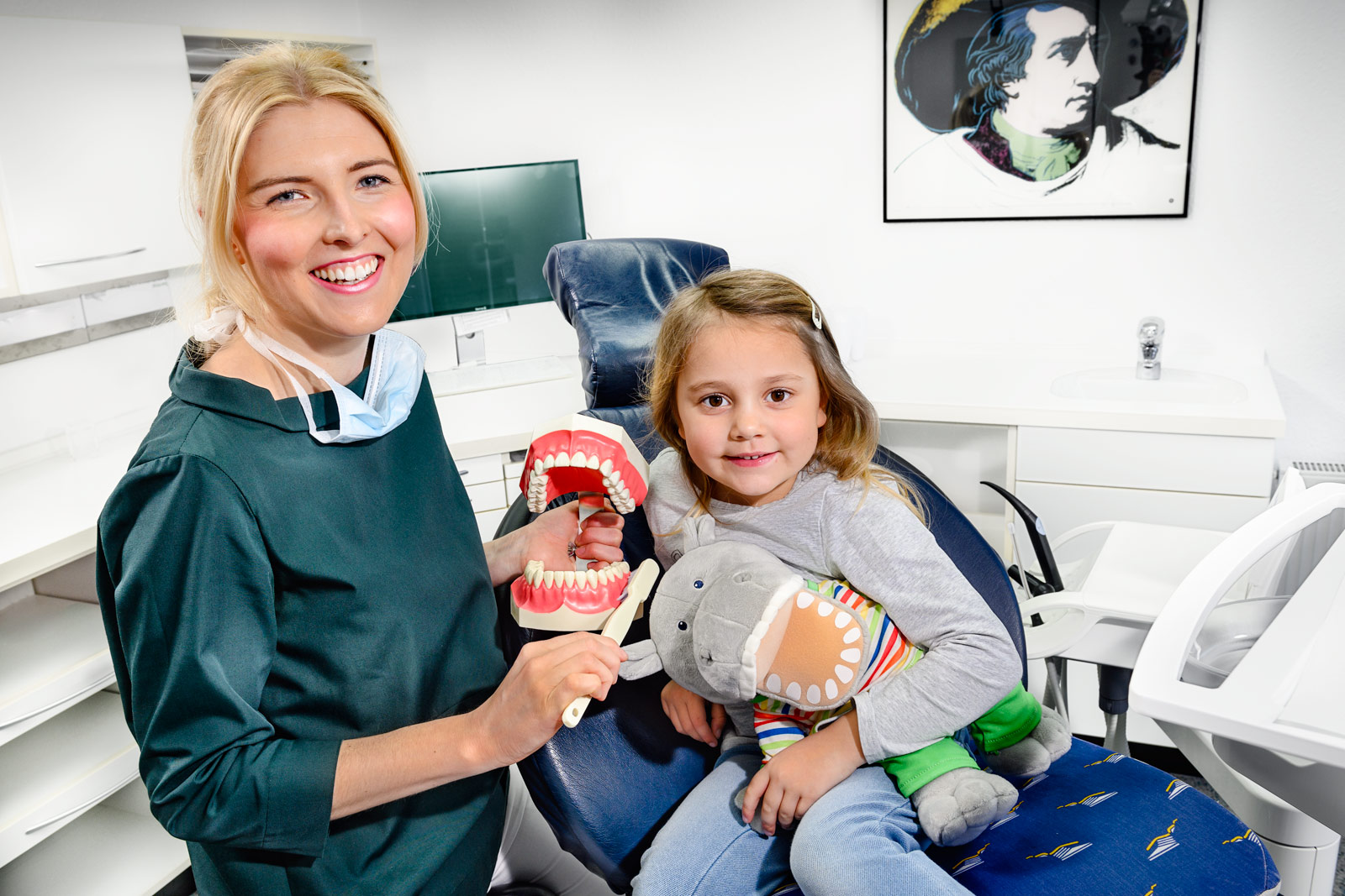 Zahnärztin erklärt an Zahnmodell einem Mädchen, wie man richtig putzt - Kinderzahnheilkunde - Zahnarzt und Fachzahnarzt Praxis Guntermann, Olpe. Foto Dietrich Hackenberg