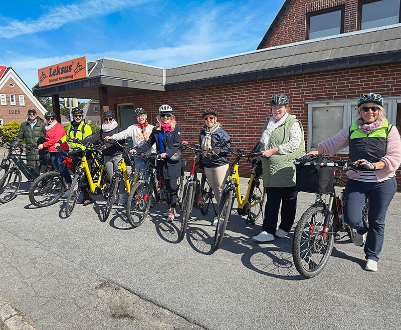 Praxisteam aufgereiht mit Fahrrädern vor dem Verleih in Sylt.