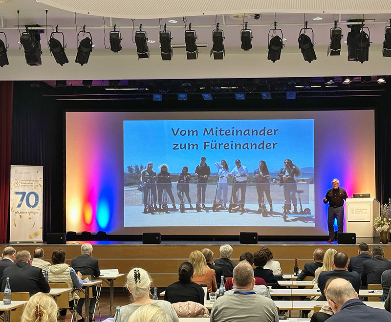 Zahnärzte Kongress Vortragender mit Projektion "Vom Miteinander zum Füreinander" mit Publikum