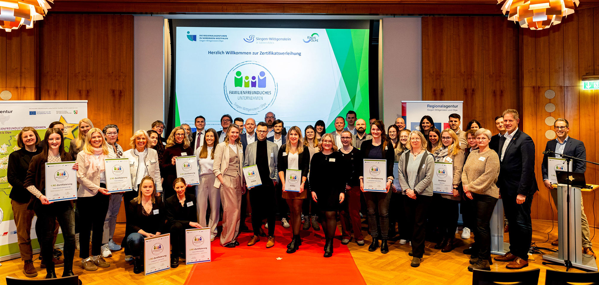 Alle ausgeseichneten Firmen auf der Bühne bei der Verleihung der Urkunde „Familienfreundliches Unternehmen“ im Haus der Siegerländer Wirtschaft in Siegen. Foto: Kreisverwaltung Siegen-Wittgenstein